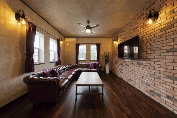 グレーの天井と壁がレンガ仕上げのアクセントウォールによく似合う～アーリーアメリカンスタイルの住まい