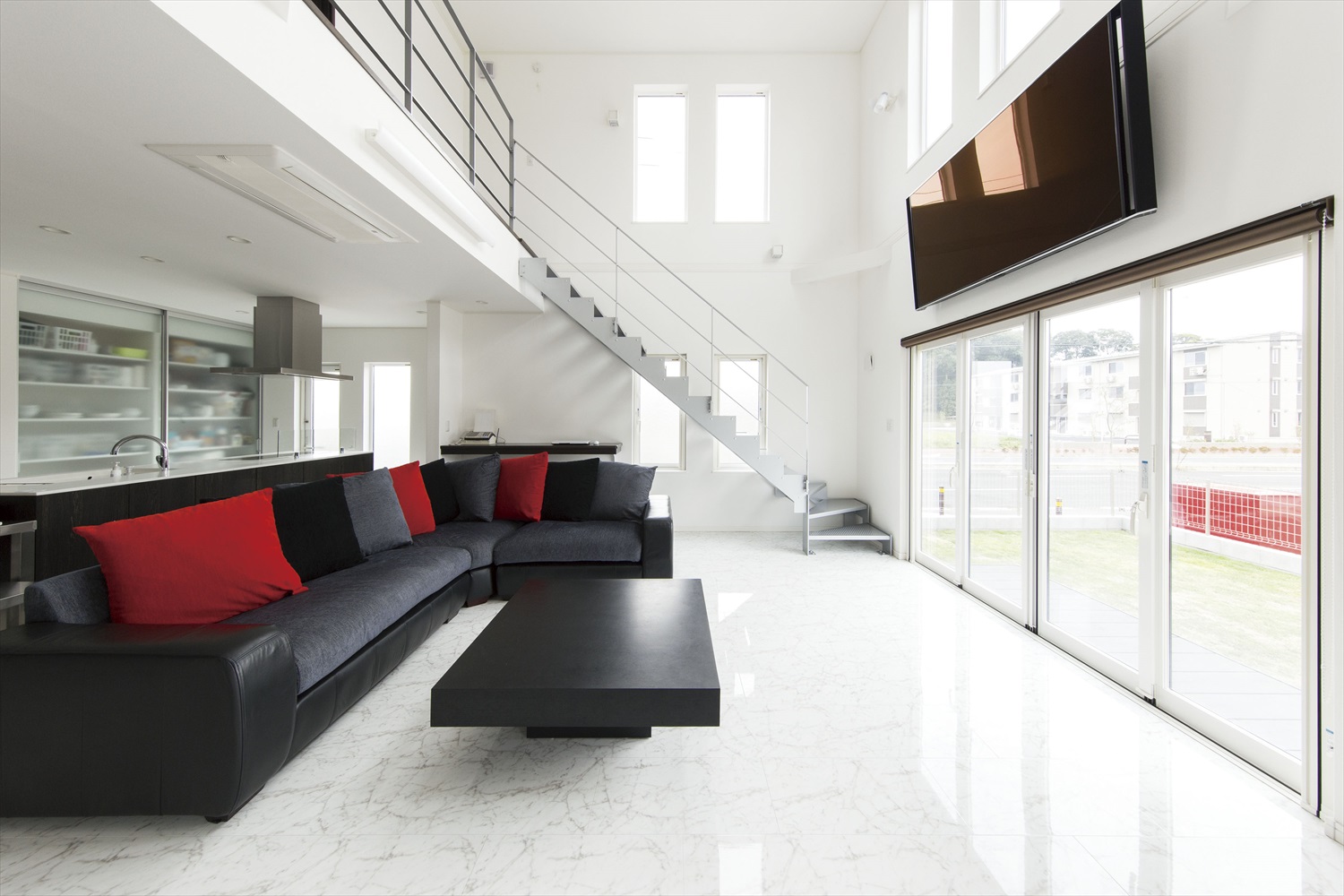 白を基調とした明るいリビングにブラック×レッドの家具が映える贅沢リビング